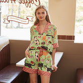 Woman wearing a green pajama set with animal print in a casual setting.